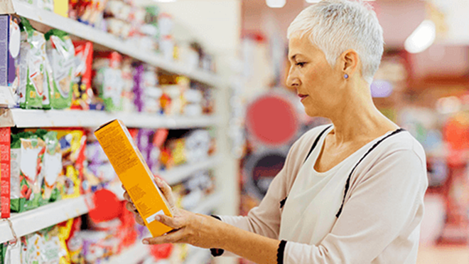 woman looking at product in a supermarket - health star ratings campaign lead